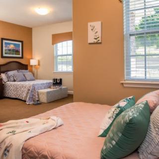 A cozy bedroom with twin beds, adorned with comfortable pillows and soft lighting.