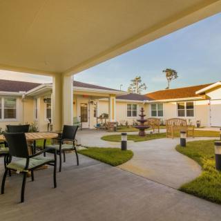 A spacious courtyard with outdoor seating and a view of a well-maintained building.