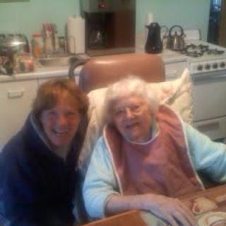 Two people smiling in a cozy kitchen setting.
