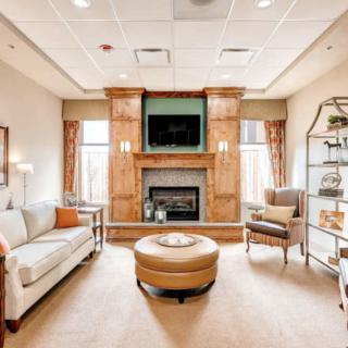A cozy and modern living room with a central fireplace, comfortable seating, and elegant decor.
