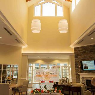 A spacious living room with high ceilings, elegant lighting fixtures, and a cozy fireplace.