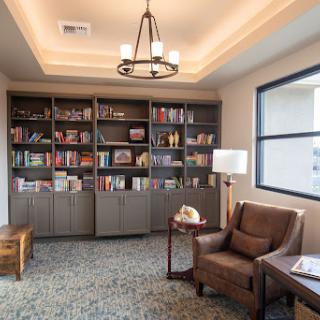 A cozy reading nook featuring a bookshelf filled with various books and comfortable seating.