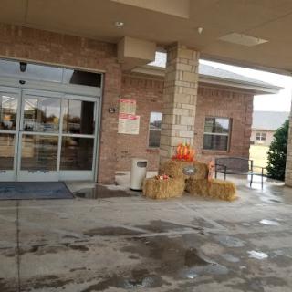 An inviting entrance decorated with pumpkins and hay bales, welcoming the fall season.