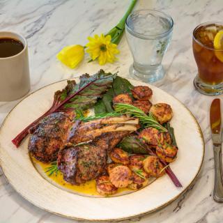 A delicious meal featuring steak and shrimp with vegetables, served alongside coffee and iced tea.