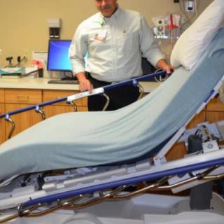 A healthcare professional adjusts a hospital bed in a medical facility setting.