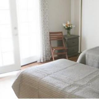 A serene and minimalist bedroom with soft natural lighting.