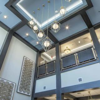 Modern interior space with a stylish chandelier and high ceiling.