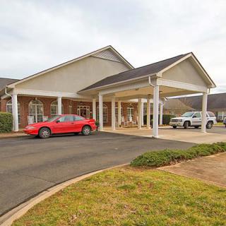 A residential building with cars parked in the driveway.