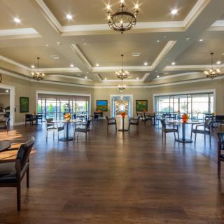 A spacious and elegantly designed dining area with chandeliers and wooden flooring.