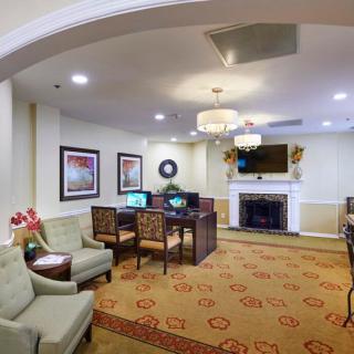 A cozy living room with a seating area, computers, and a fireplace.