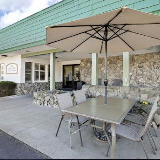 A cozy outdoor seating area with a table, chairs, and an umbrella, perfect for enjoying meals al fresco.