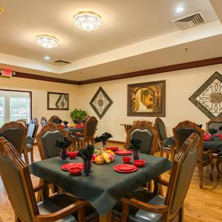 A well-decorated dining room with elegantly set tables and artwork adorning the walls.