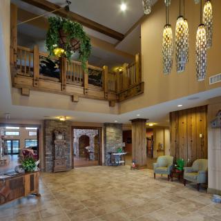 A spacious lobby with elegant wooden accents and modern chandeliers.