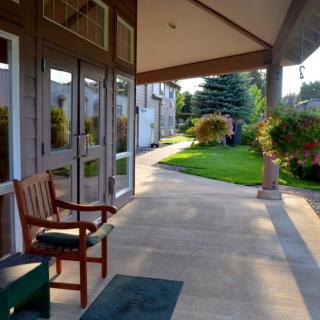 A peaceful porch overlooking a garden walkway bathed in sunlight.