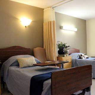 A well-lit healthcare room with two beds, offering a comforting atmosphere.