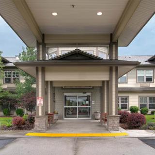 The entrance of a modern building with well-maintained landscaping.
