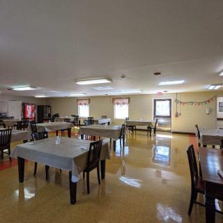An empty dining room with tables and chairs arranged neatly.