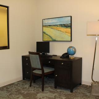 A modern office space featuring a desk with a computer, a globe, and artwork on the wall.