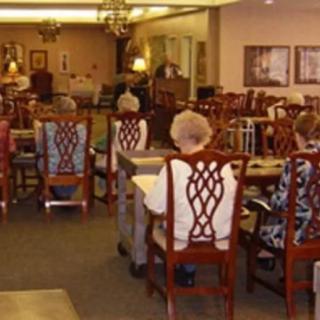 A group of elderly people seated in a dining area of a community center.