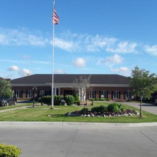 A welcoming building with well-maintained landscaping and an American flag flying in front.