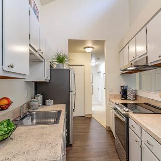 A modern galley-style kitchen in an apartment with sleek countertops and cabinets.