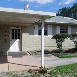 A single-story house with a small front porch and neatly trimmed shrubbery.