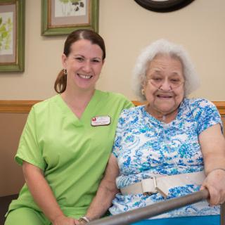 A caregiver and an elderly resident share a joyful moment together.