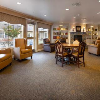 A cozy living room with comfortable seating, a fireplace, and large windows providing ample natural light.