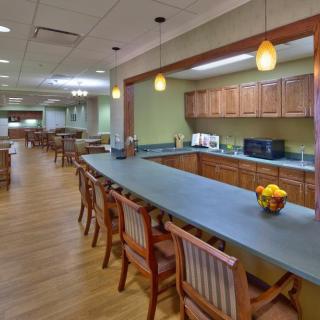 A spacious kitchen and dining area with wooden furniture and modern lighting.