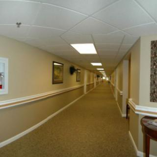 A long, carpeted hallway with framed pictures on the walls.