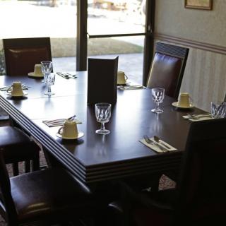 A neatly set dining table in a restaurant with glasses, cutlery, and napkins.