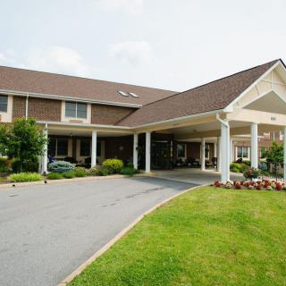 A residential building with a covered entrance and landscaped surroundings.