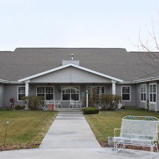 A view of a residential building with a garden and pathway leading to the entrance.