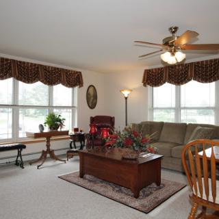 A cozy and well-lit living room featuring comfortable furniture and decorative elements.