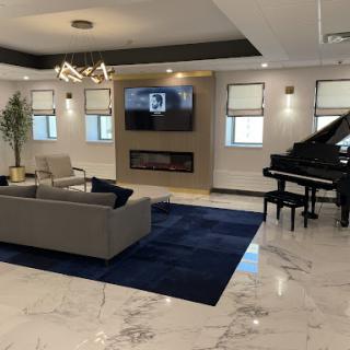 A stylish modern living room featuring a grand piano, comfortable seating, and elegant decor.