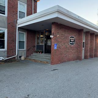 The entrance of a brick building with a ramp for accessibility.