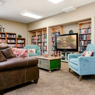 A cozy living room with bookshelves and comfortable seating.