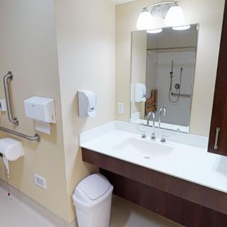 A clean, well-lit bathroom with a sink and mirror.