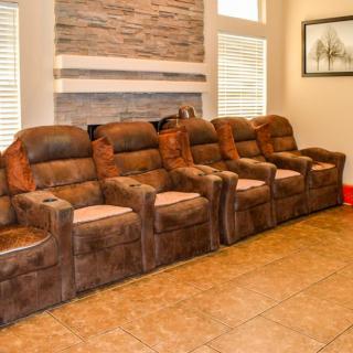 A cozy home theater setup with a row of plush recliner chairs.