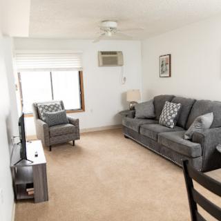 A cozy and inviting living room featuring a comfortable sofa, armchair, and a television.