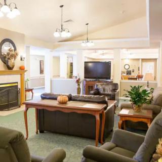 A cozy and well-furnished living room with a fireplace, television, and comfortable seating.