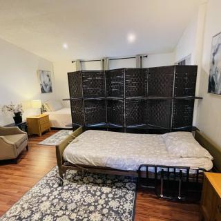A cozy bedroom setup featuring a bed, armchair, and room divider with modern decor.