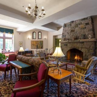 A cozy living room with a large stone fireplace and comfortable seating.
