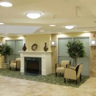 A modern lobby area with a fireplace, seating, and decorative plants.