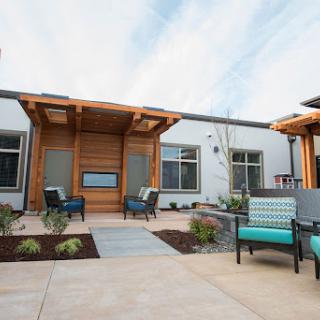 A modern courtyard featuring stylish outdoor seating and landscaped gardens.