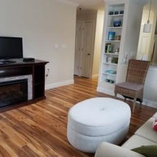 Cozy living room with a fireplace and wooden flooring.
