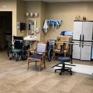 A physical therapy room equipped with wheelchairs and various rehabilitation tools.