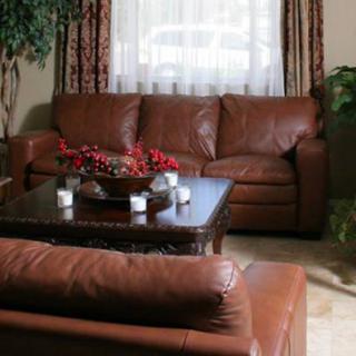 A cozy living room with leather sofas and a wooden coffee table.