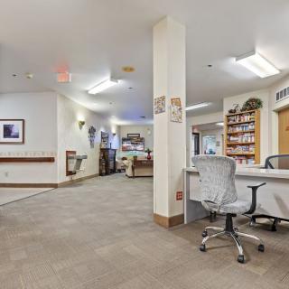 A spacious office interior with desks, chairs, and bookshelves in a reception area.