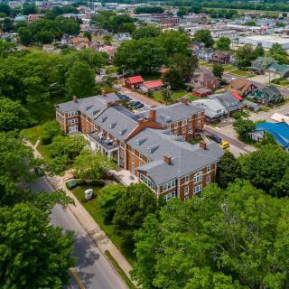 Aerial view of a residential building surrounded by trees in a neighborhood setting.